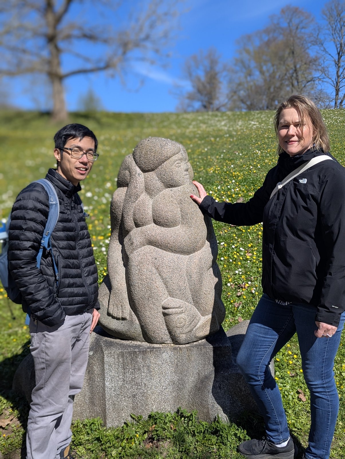 Daiga och en gäst vid den sittande mor-och-barn-skulpturen vid Dainernas kulle, Turaida