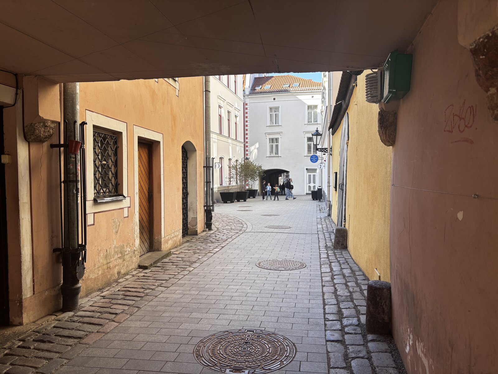 Den kullerstenslagda inre gången i Konventa Sēta, den medeltida klostergården i Gamla stan i Riga