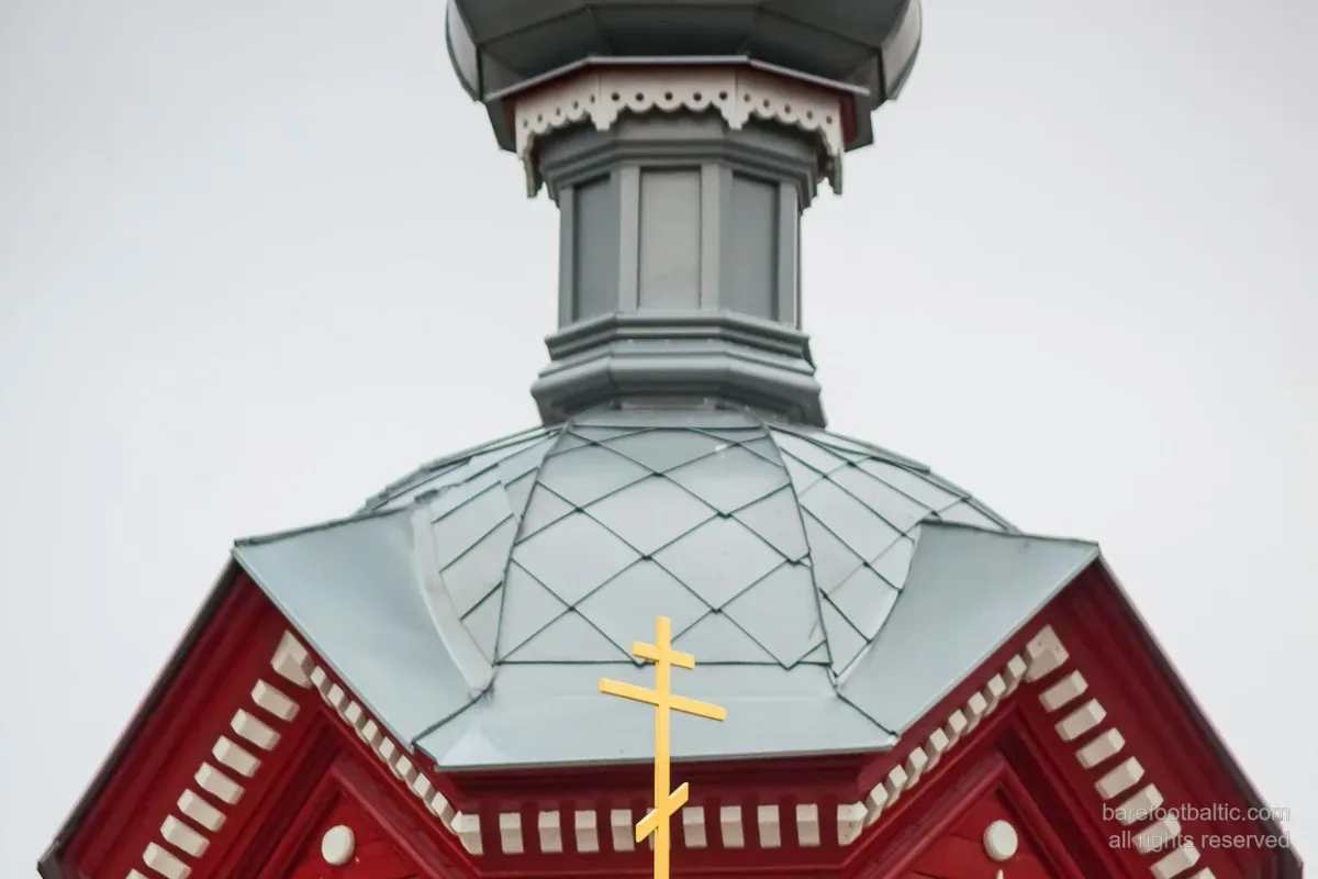 En ortodox träkyrka med lökkupol och det åttauddiga trebalkiga ortodoxa korset, Lettland.