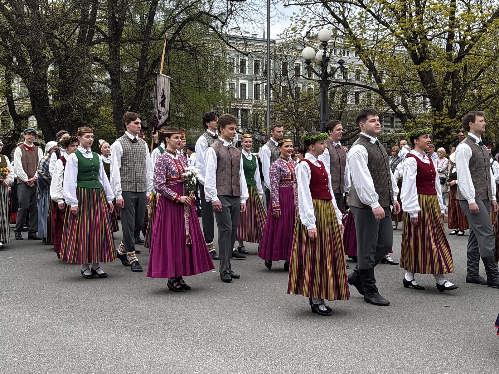 Den lettiska arméns hedersvakt vid Frihetsmonumentet med en vägg av blommor lagda mot sockeln, Riga, på dagen för återställd självständighet