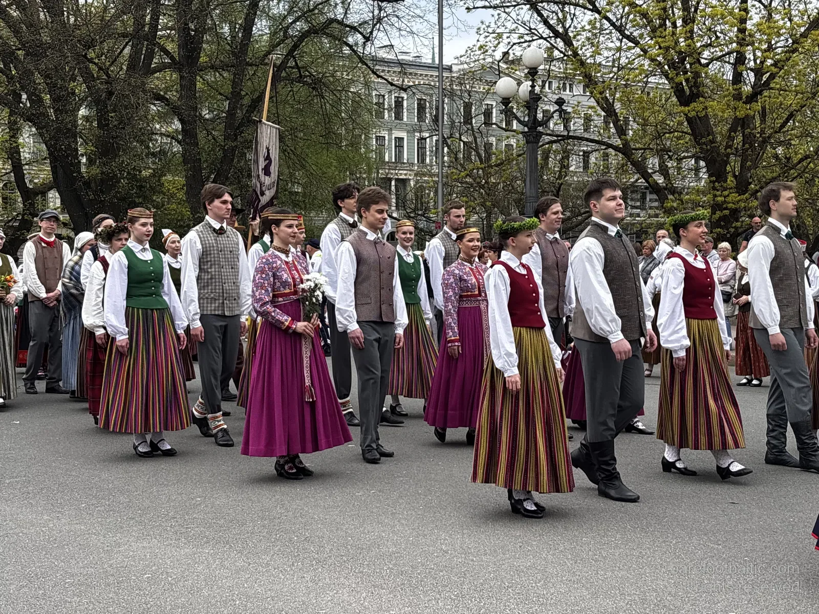 Den lettiska arméns hedersvakt vid Frihetsmonumentet med en vägg av blommor lagda mot sockeln, Riga, på dagen för återställd självständighet
