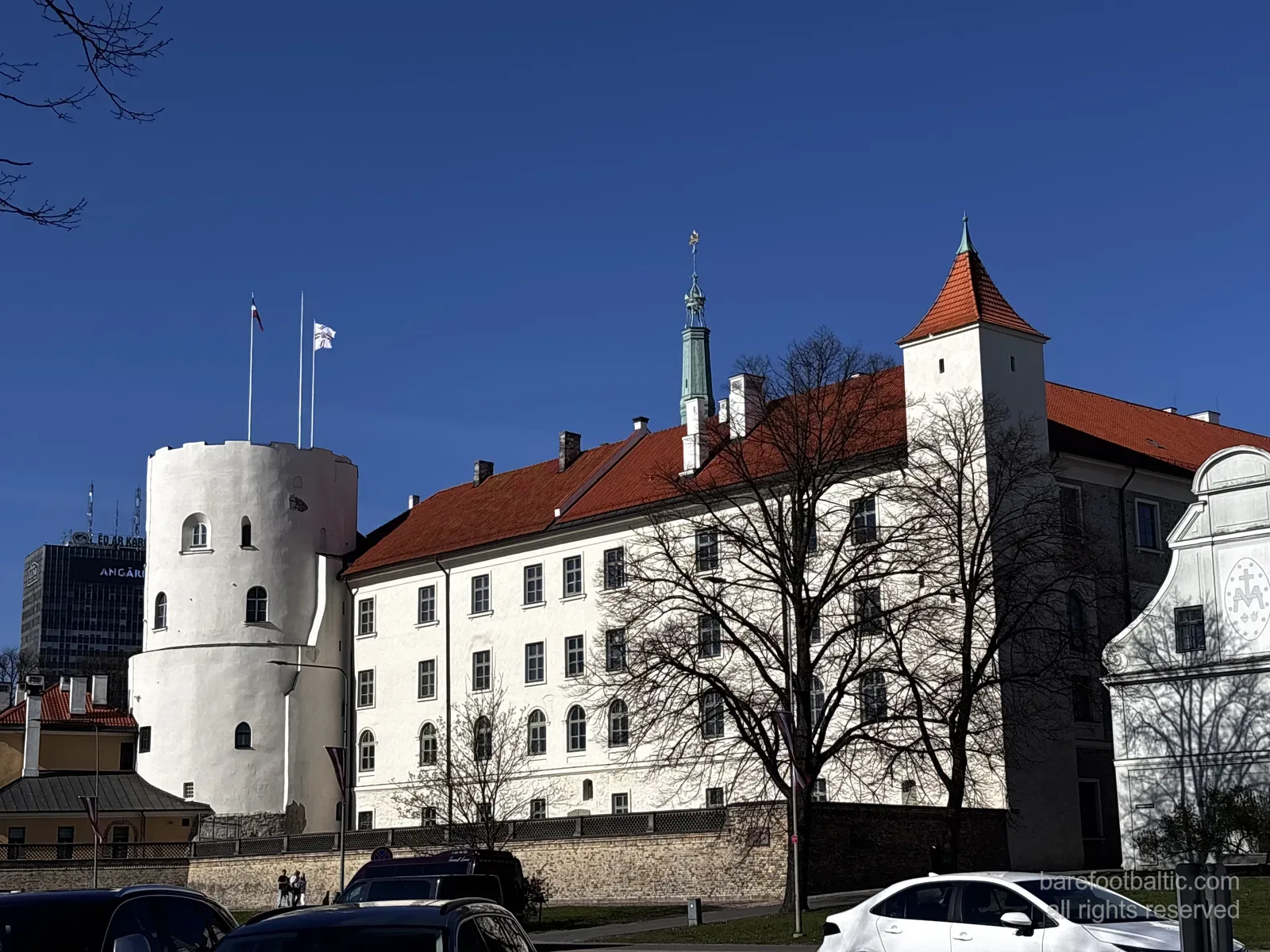 Rigas slott (Rīgas pils) med sina vita murar, röda tak och det runda Svētā Gara tornis i Riga, Lettland.