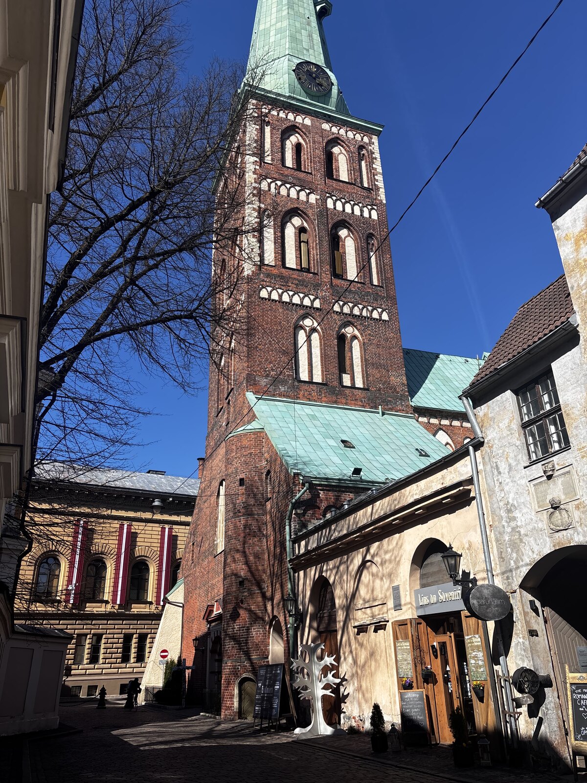 Sankt Jakobs katedral (Sv. Jēkaba katedrāle) på Jēkaba iela i Rigas Gamla stan, Lettland, en hög smal gotisk spira över en kropp av tegel.