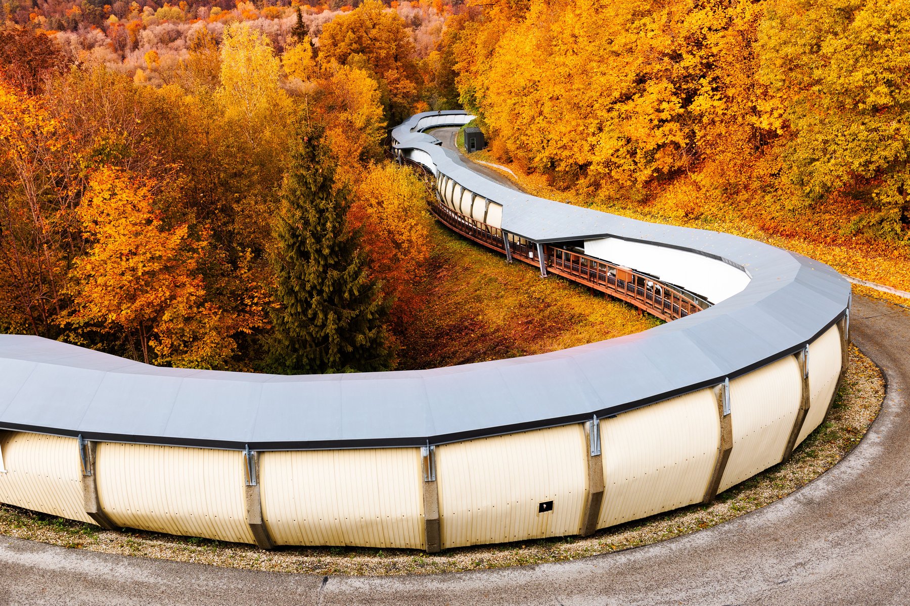 Den olympiska bobbanan i Sigulda som ringlar genom höstskogen